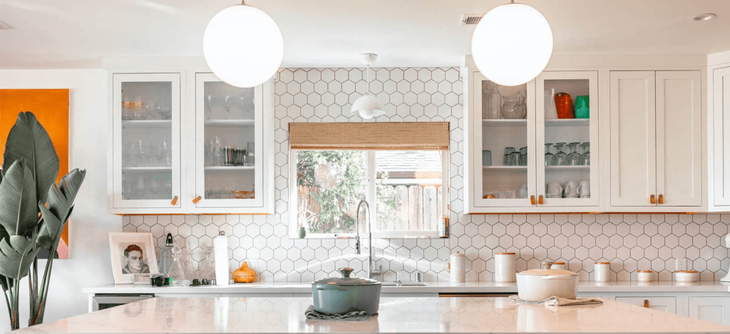 Modern kitchen featuring hexagonal tile backsplash, white cabinetry, and decorative accents, emphasizing stylish design and quality craftsmanship in home remodeling.