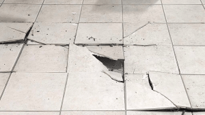 Cracked floor tiles illustrating common issues in tile installation and maintenance.