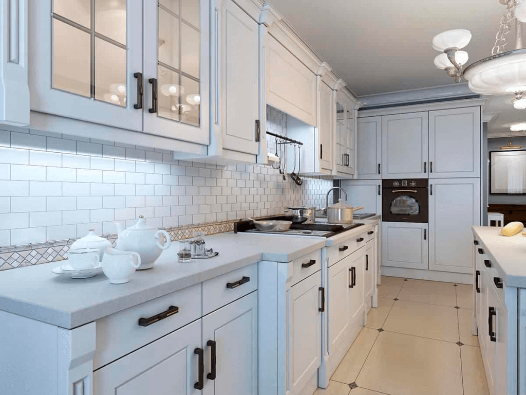 White kitchen featuring a stylish backsplash, modern cabinetry, and elegant countertop accessories, showcasing NW Tile and Flooring's renovation expertise.